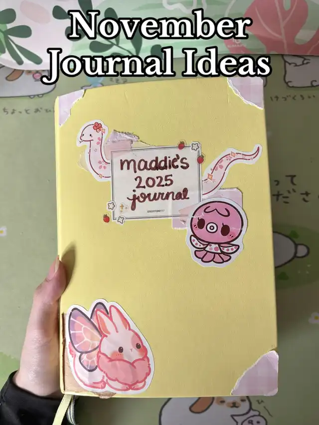 A yellow journal cover with various stickers, including a pink bunny with butterfly wings, a pink octopus, and a label that reads "maddie's 2025 journal." The title "November Journal Ideas" is overlaid on the image.